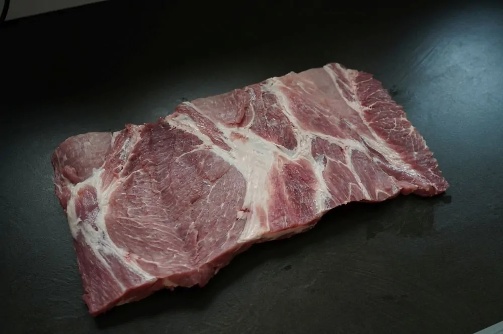 Der Schweinenacken wird aufgeschnitten und gewürzt