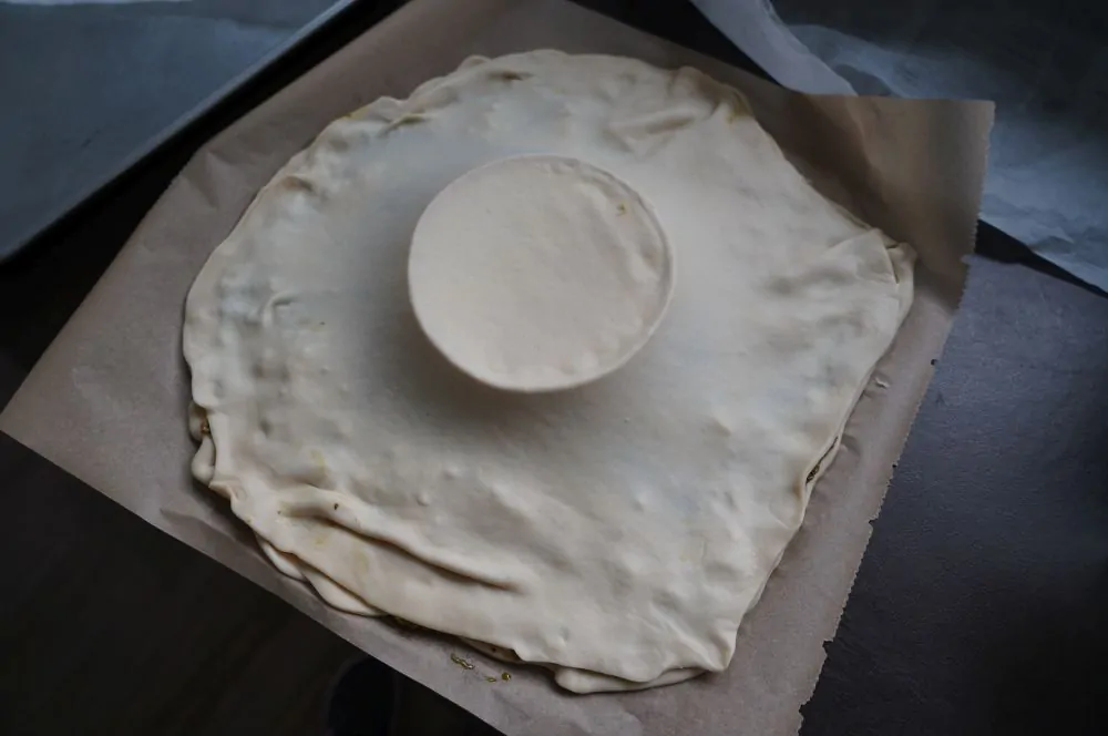 Der zweite Pizzateig wird über den Ofenkäse gelegt
