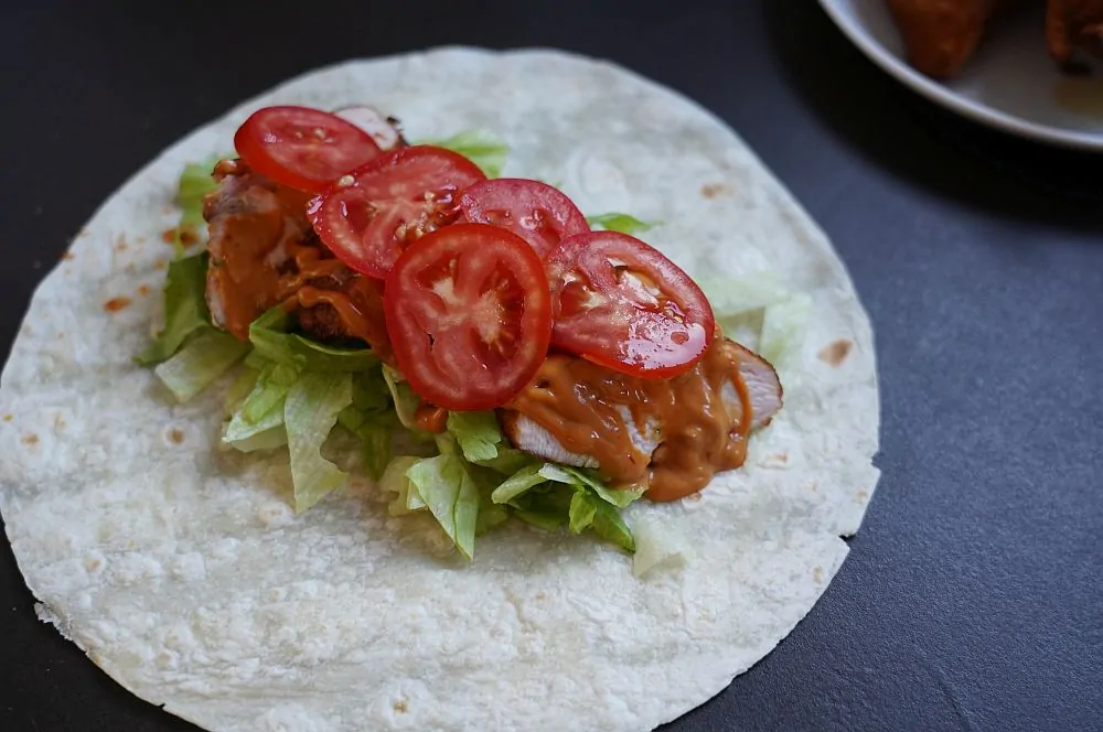 Smoked Chicken Wrap mit Tomate und Avocado 6 Der Smoked Chicken Wrap wird belegt
