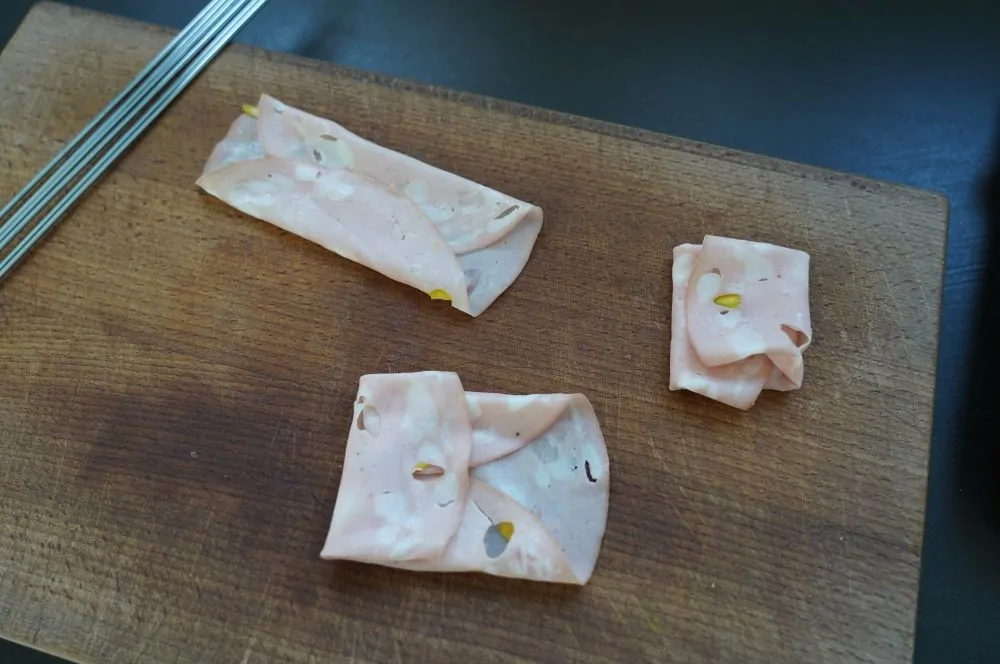 Die Mortadella-Scheiben werden gefaltet