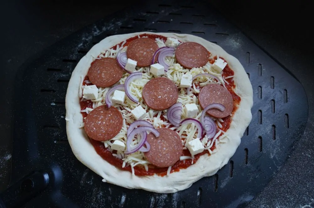 Die Sucuk-Pizza wird belegt