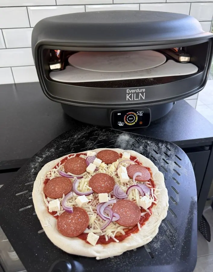 Die Sucuk-Pizza wird in den Pizzaofen geschoben