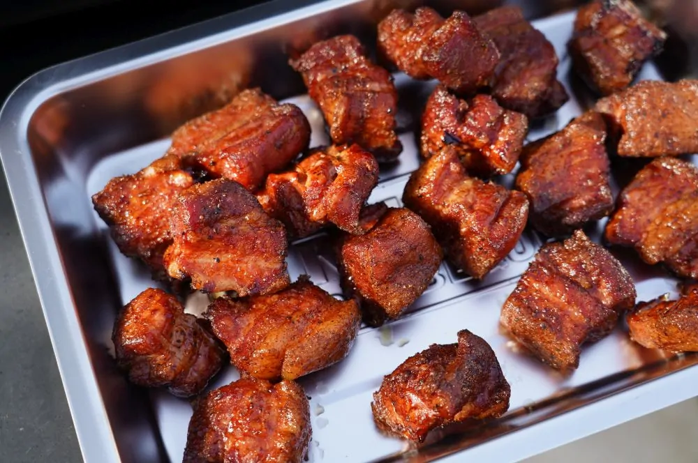 Die Schweinebauchwürfel werden in einer Edelstahlschale gedämpft